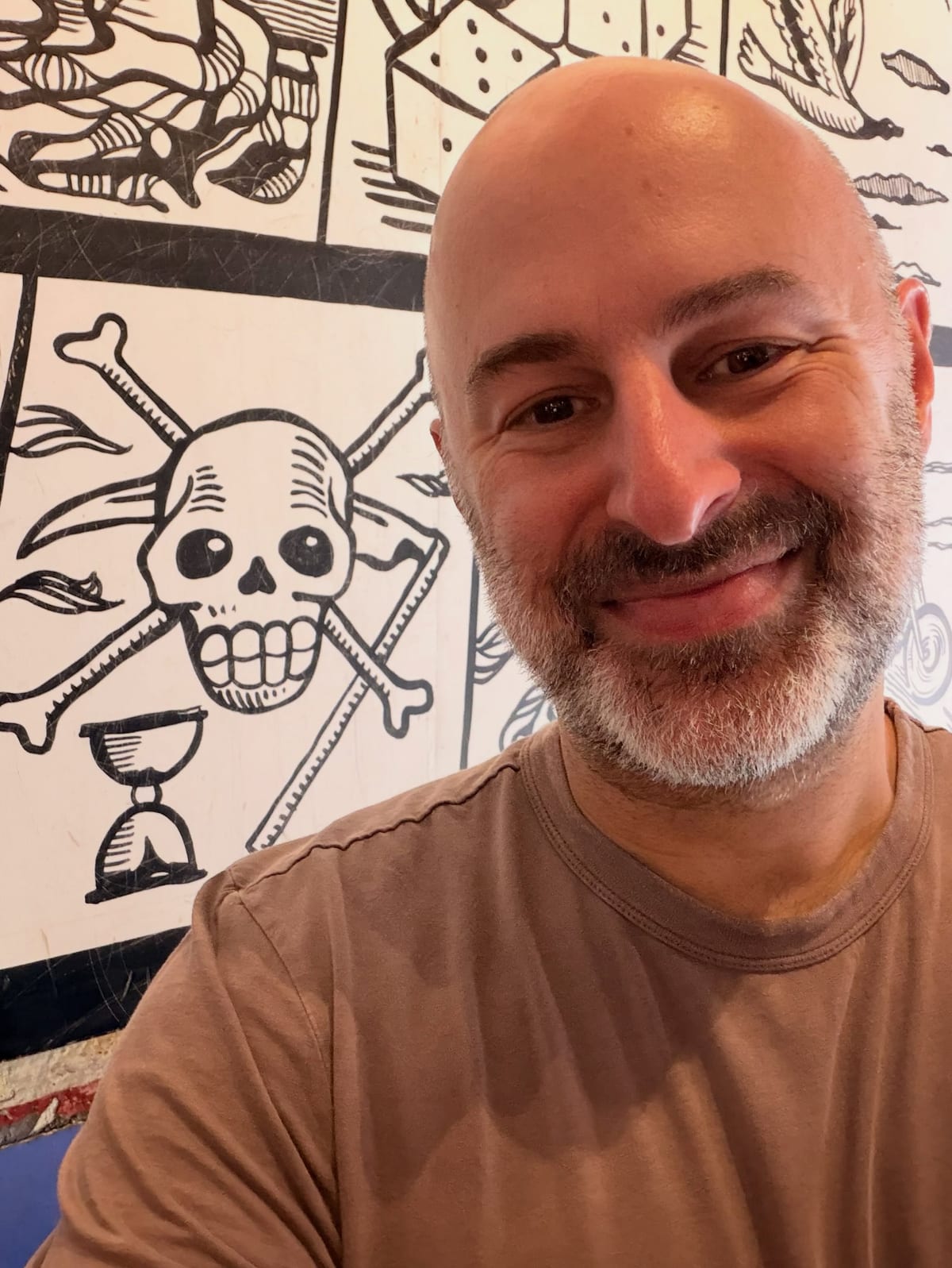 Aaron smiling in front of a black-and-white mural in San Miguel de Allende